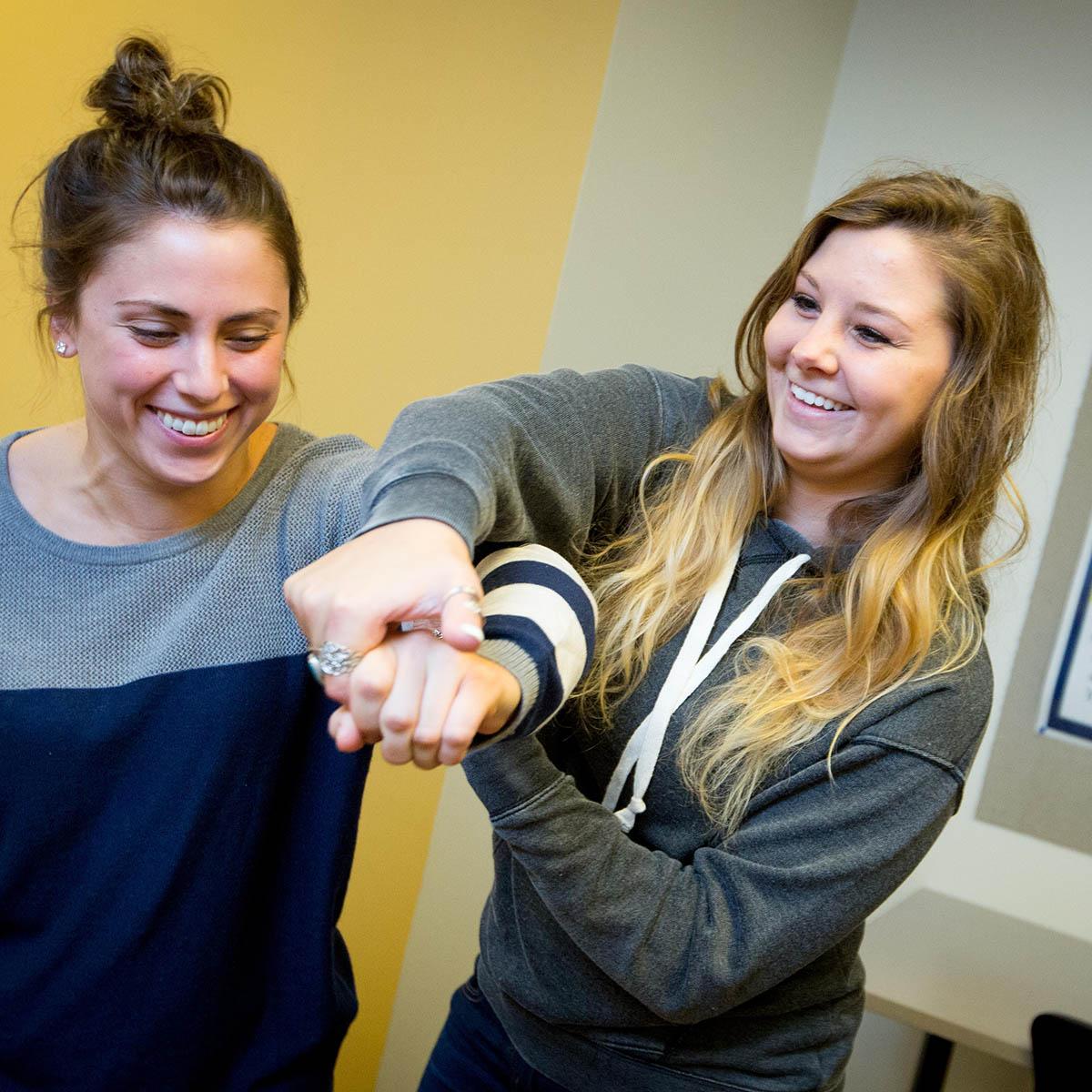 Photo of two occupational therapy students smiling and working together