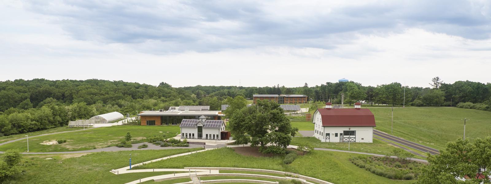 Aerial photo of Chatham University's Eden Hall Farm campus featuring the dairy barn, Eden Hall Commons, walking paths and fields. 