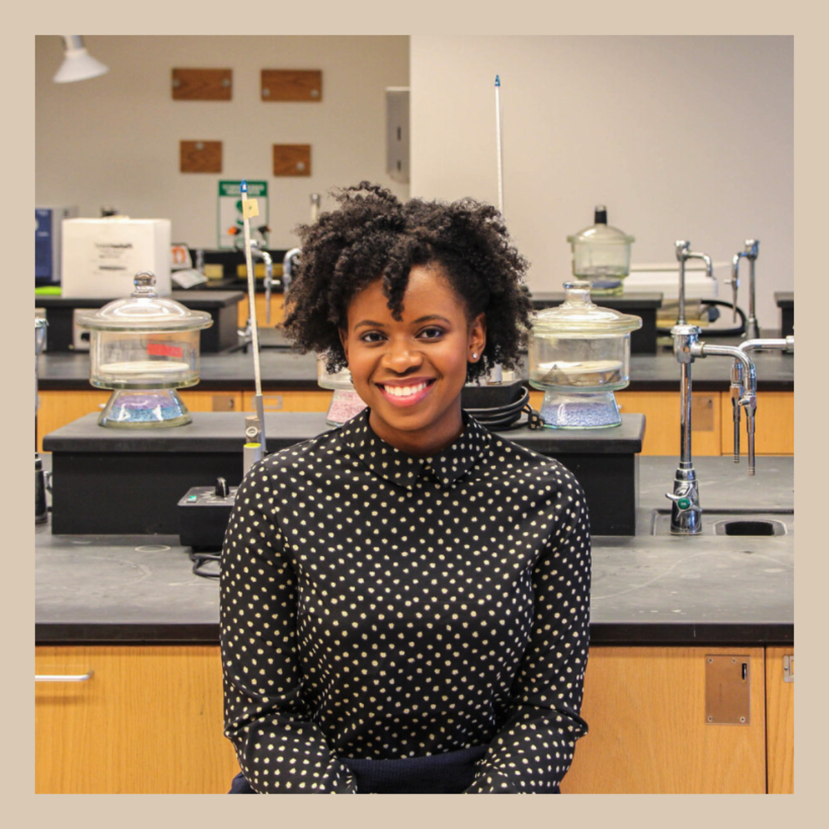 Photo of a young Black woman smiling in a laboratory