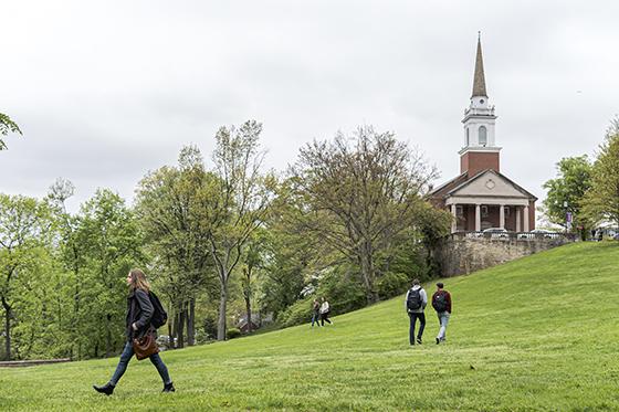 Photo of Chatham University students walking across the grassy Shadyside Campus