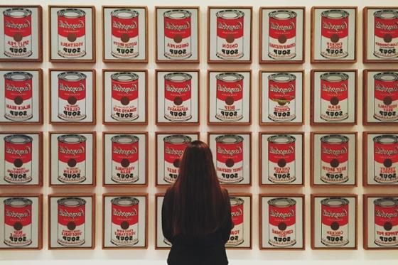 Photo of a woman standing in front of Andy Warhol soup can artwork at art museum in Pittsburgh. 