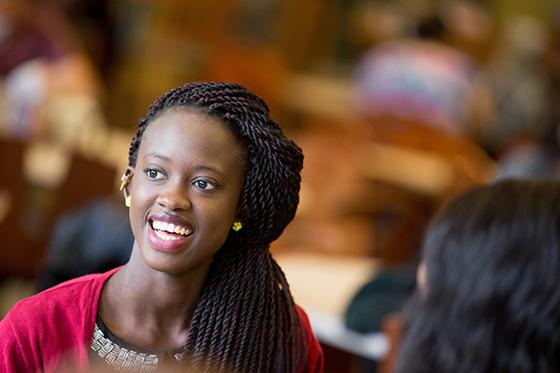 Photo of a young Black woman smiling in Chatham University's Anderson Dining Hall